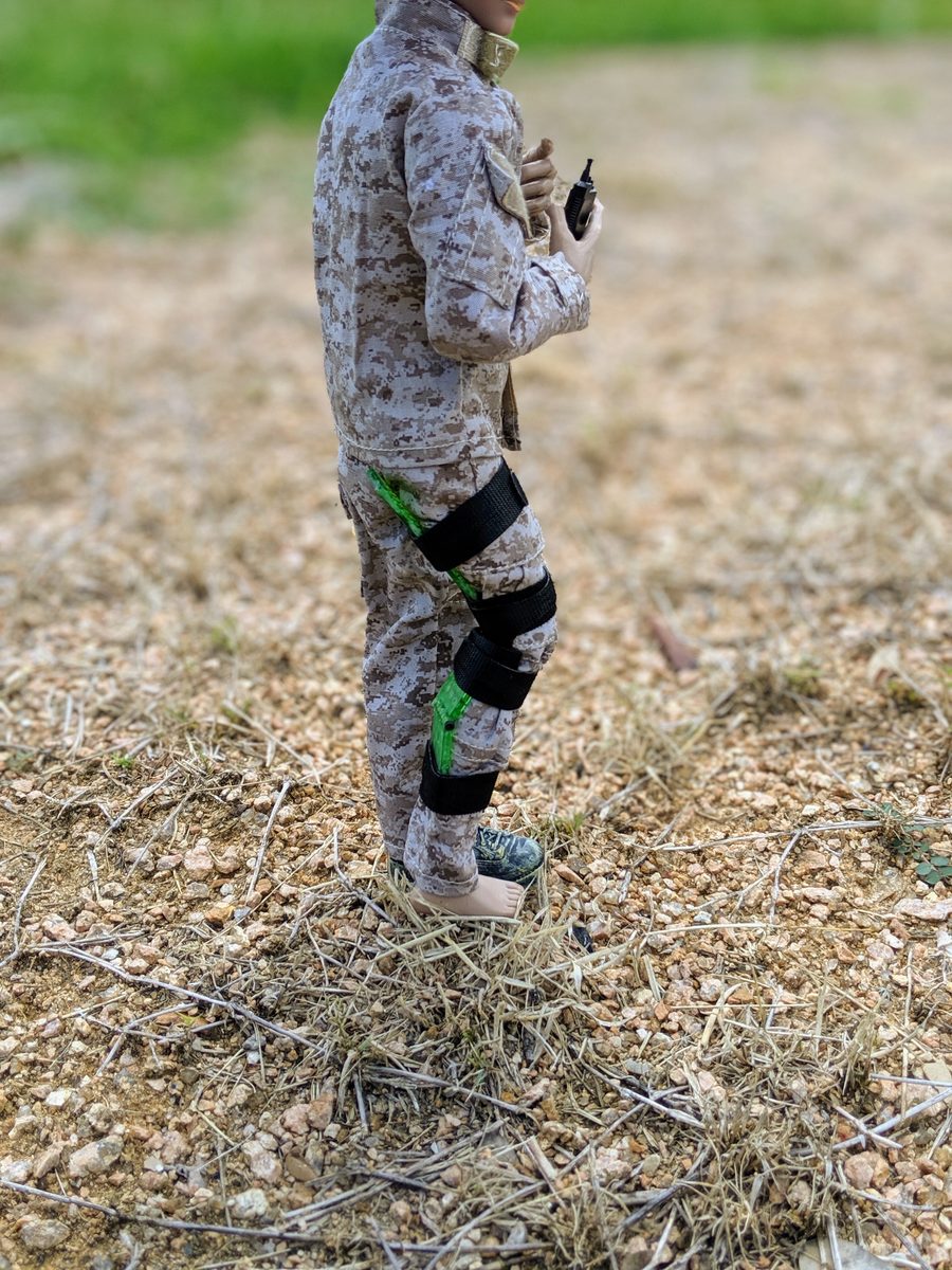Neon-green Set-Lock Splint prototype strapped along an action-figure lower leg