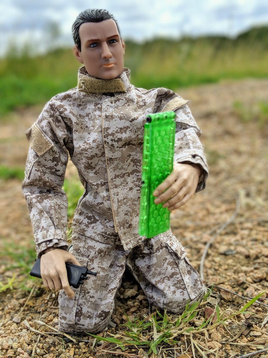Action figure holding translucent neon-green honeycomb Set-Lock plate prototype outdoors